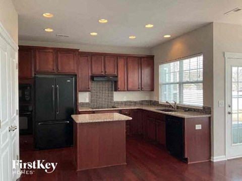 a large kitchen with black appliances and wooden cabinets