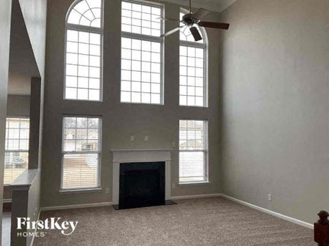 a large living room with a fireplace and large windows