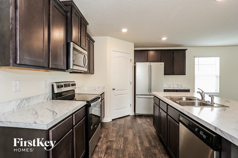 A kitchen with dark brown cabinets and a white counter top.