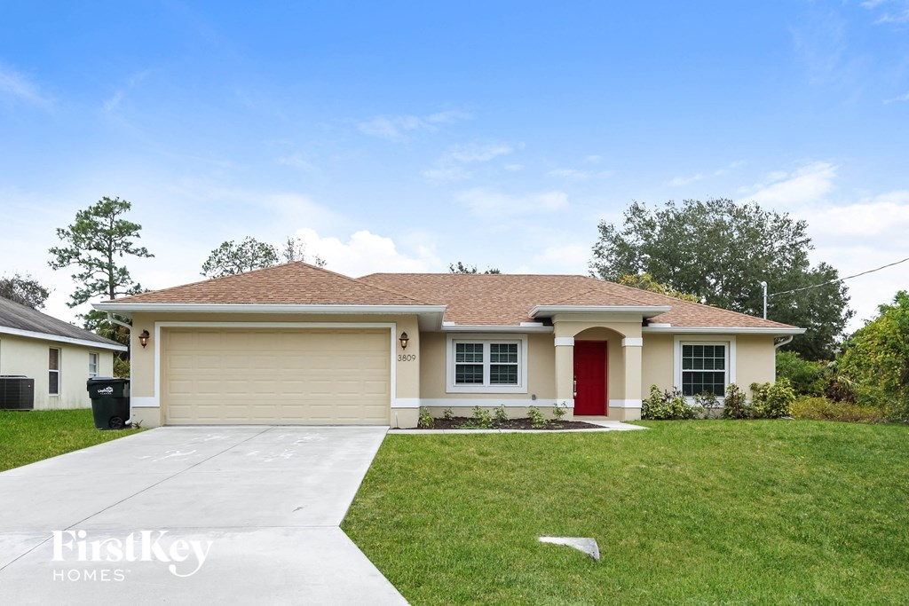 a beige house with a red door