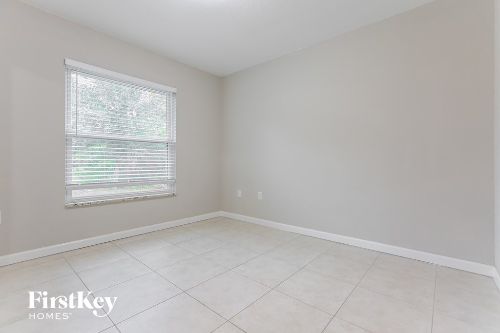 an empty room with a window and a tiled floor