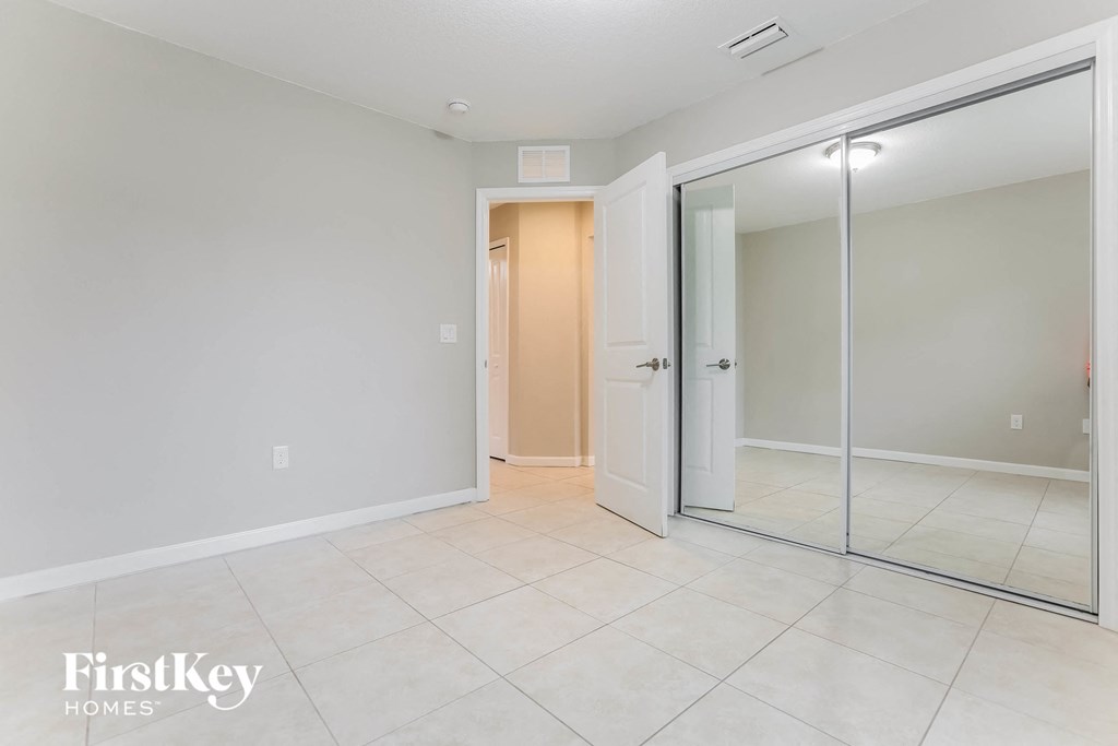 a room with a white tile floor and sliding glass doors