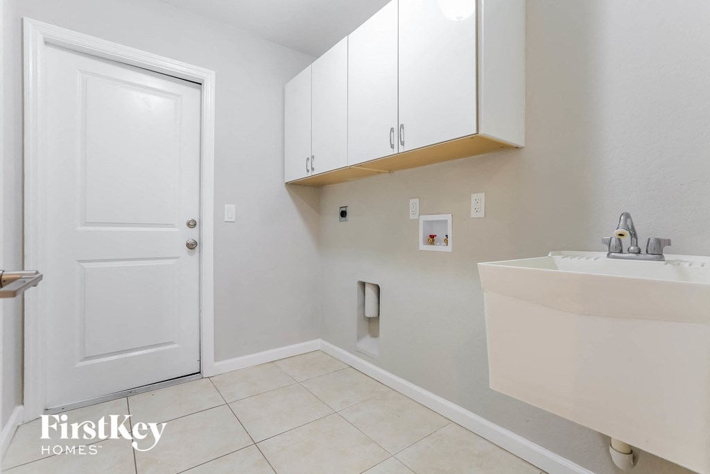 a bathroom with white cabinets and a sink and a white door