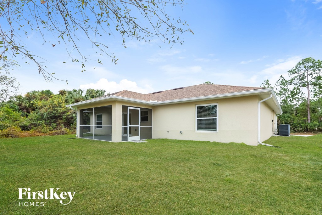 a small house with a grassy yard and a backyard