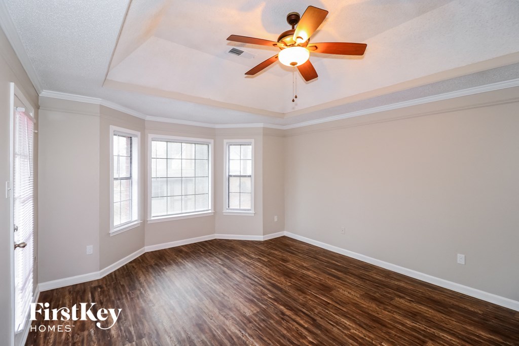 the living room of an empty house with a ceiling fan
