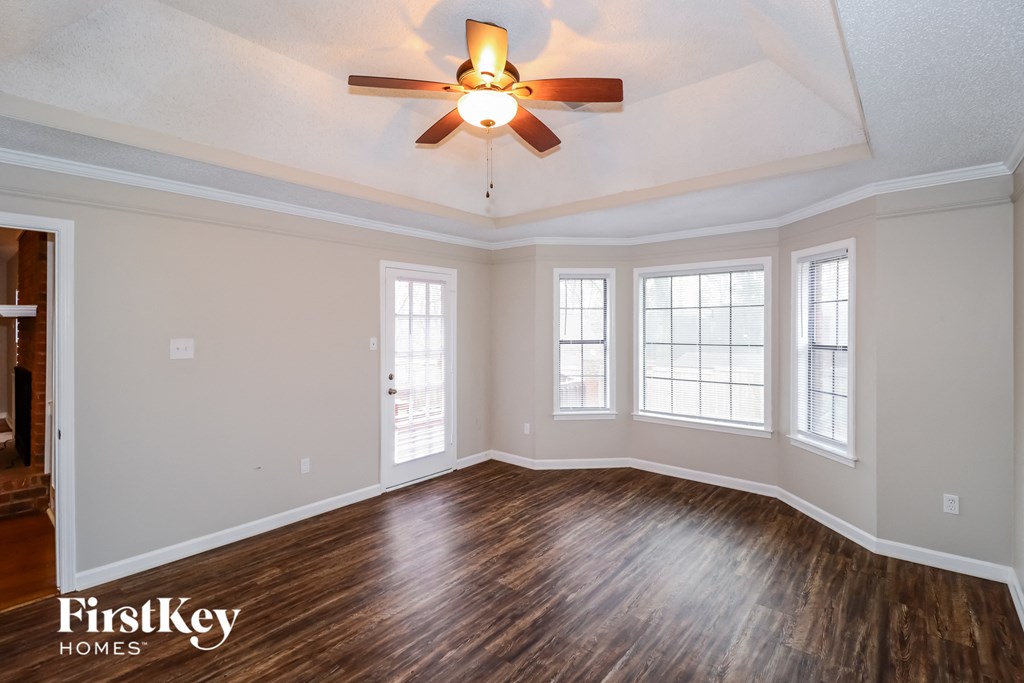 the living room of an empty house with a ceiling fan