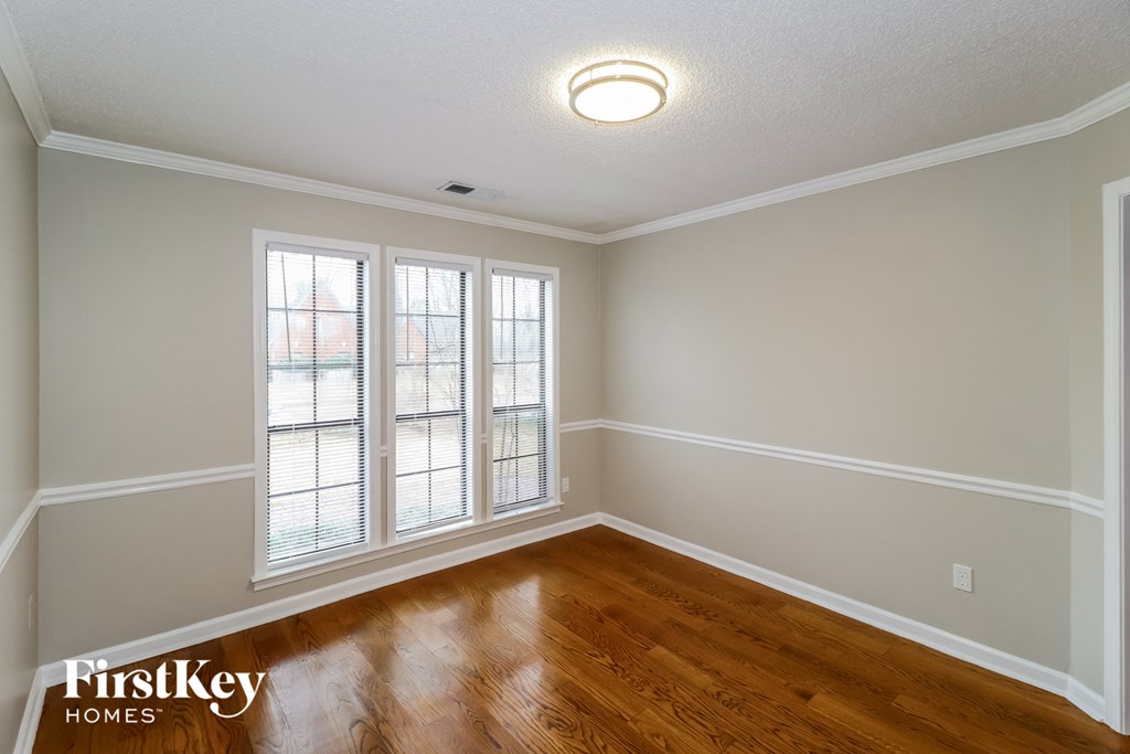 the living room of an empty house with wood flooring and windows