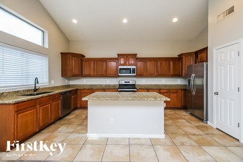 A kitchen with brown cabinets and a white island.