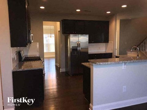 A kitchen with black cabinets and a granite countertop.