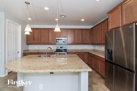 a kitchen with granite counter tops and wooden cabinets