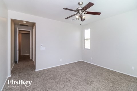 a bedroom with carpet and a ceiling fan