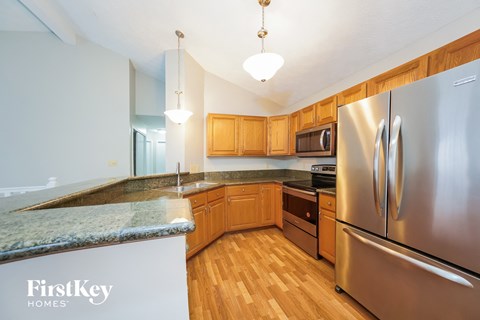 a kitchen with wooden cabinets and stainless steel appliances and granite counter tops