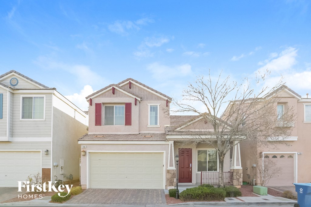 a beige house with a garage and a blue sky