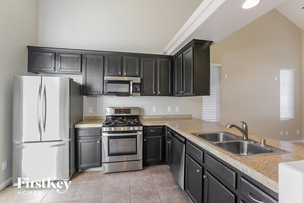 a kitchen with stainless steel appliances and black cabinets