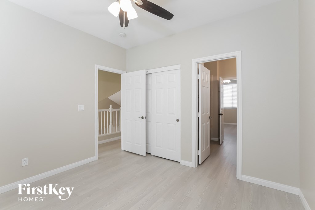 a bedroom with two closets and a ceiling fan
