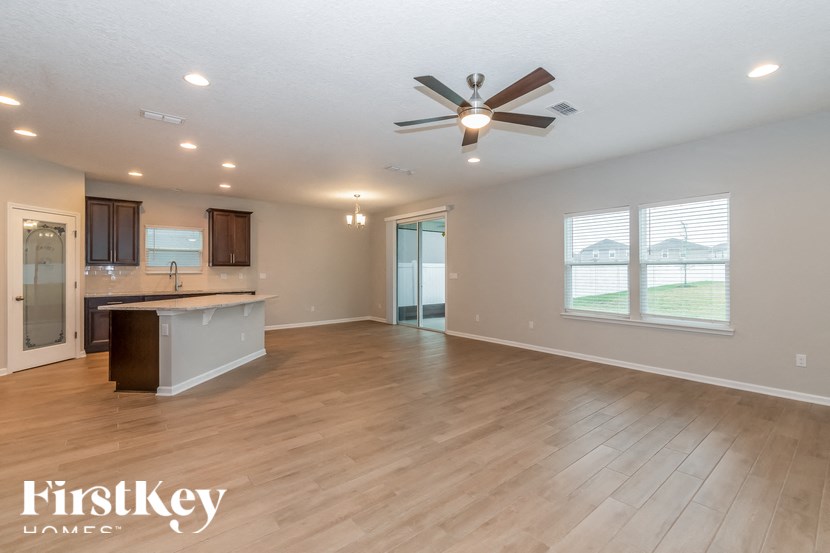 A spacious room with a ceiling fan and wooden flooring.
