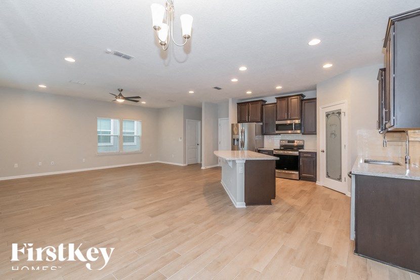 A spacious kitchen with wooden floors and a large island in the middle.