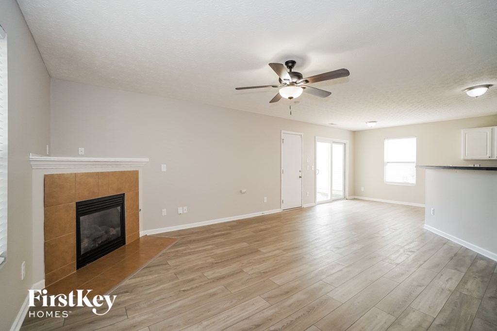 A spacious room with a fireplace and wooden flooring.