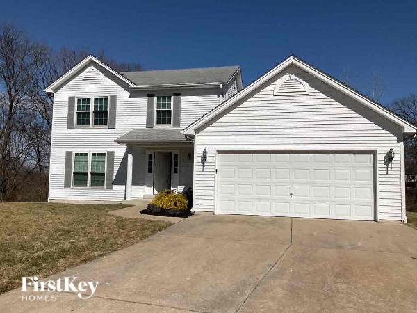 A white house with a garage door and a small front yard.