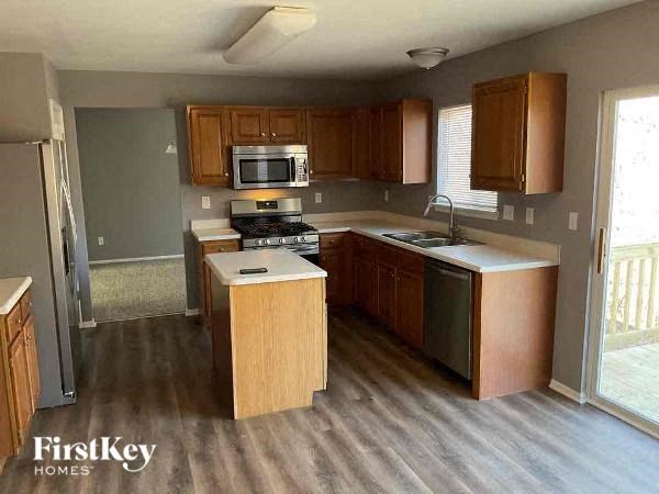 A kitchen with wooden cabinets and a stove top oven.