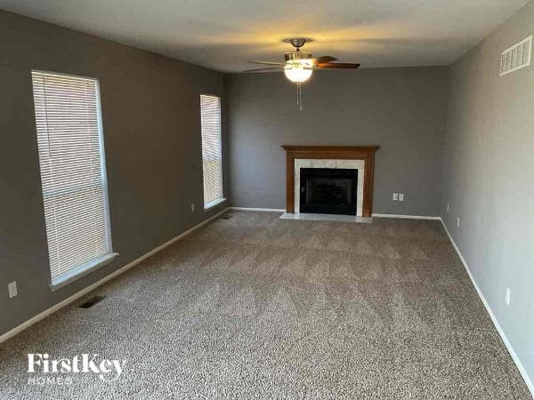 A room with a fireplace and a ceiling fan.