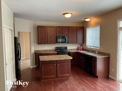 A kitchen with wooden cabinets and a granite countertop.