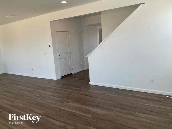 an empty living room with white walls and wood floors