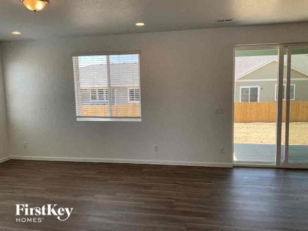 an empty living room with wood floors and glass doors