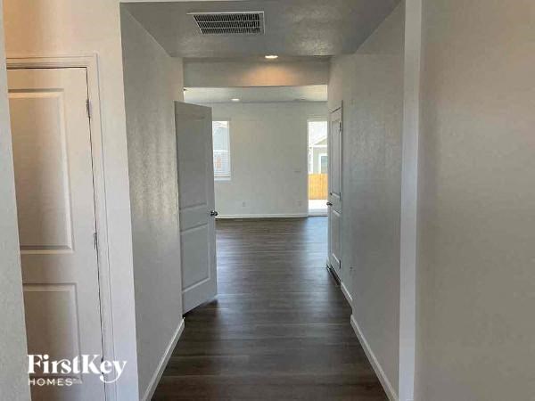 a hallway with white walls and a wood floor