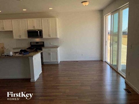 A kitchen with wooden floors and white cabinets.