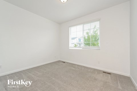 a bedroom with white walls and a window