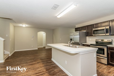 A kitchen with a white counter top and stainless steel appliances.