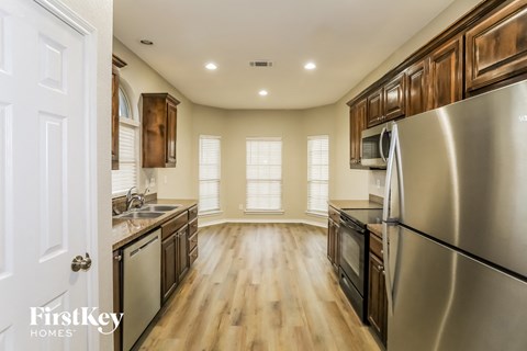 A modern kitchen with wooden cabinets and stainless steel appliances.