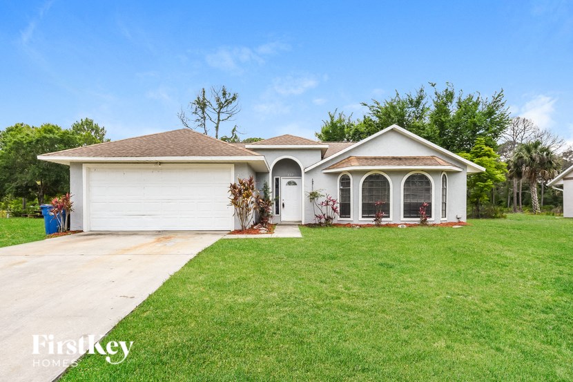a white house with a lawn and a garage
