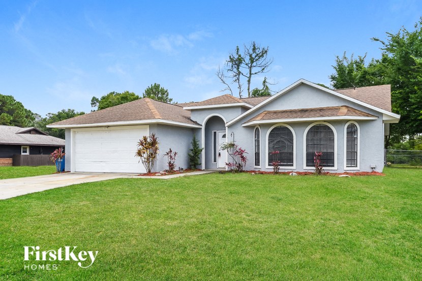 a white house with a lawn and a garage