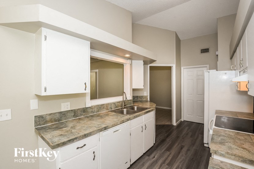 a kitchen with white cabinets and a sink and a refrigerator