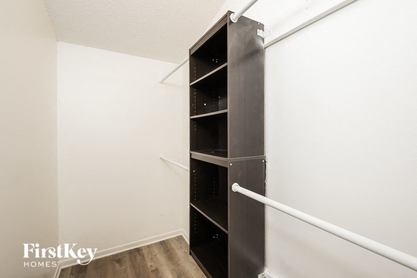 a closet in a small room with a black shelving unit