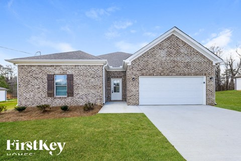 A brick house with a garage door and a window.
