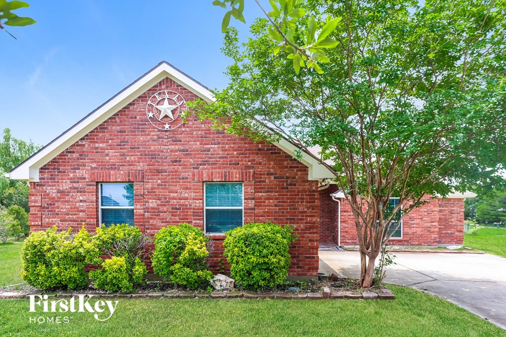 A brick house with a tree in front of it.