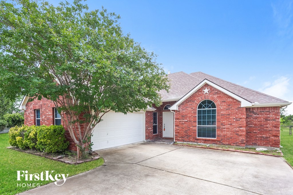A brick house with a tree in front of it.
