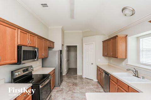 A kitchen with brown cabinets and a black stove top oven.