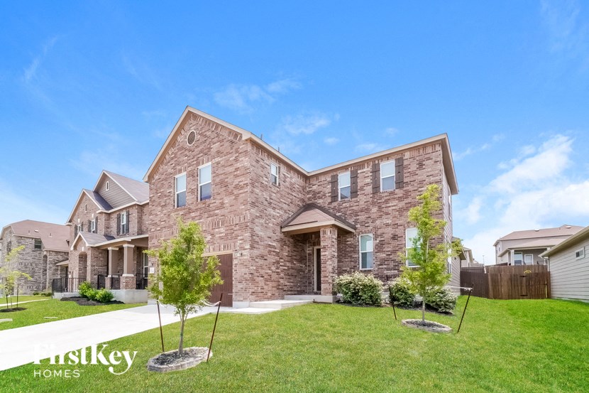 A large brick house with a lawn in front.