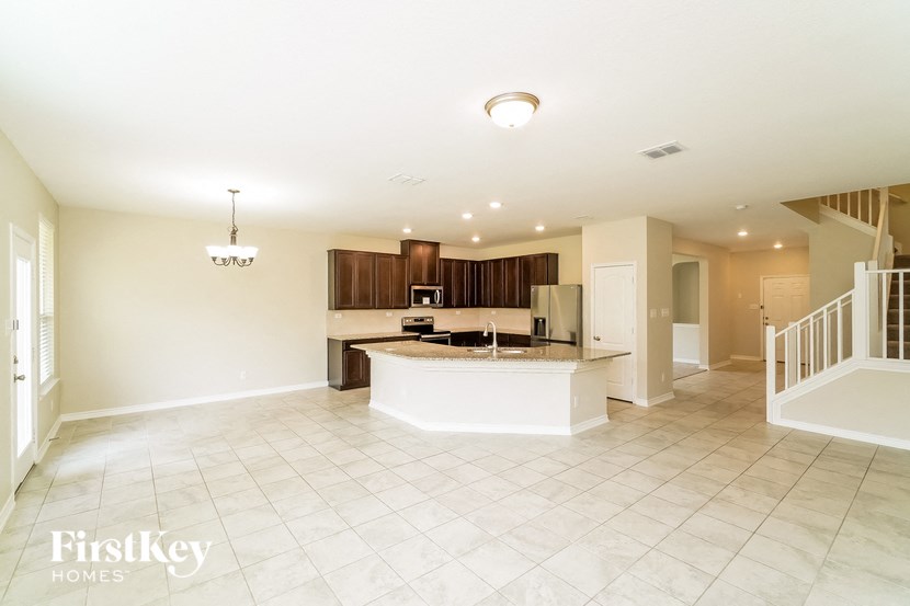 A spacious kitchen with a white countertop and a stainless steel refrigerator.