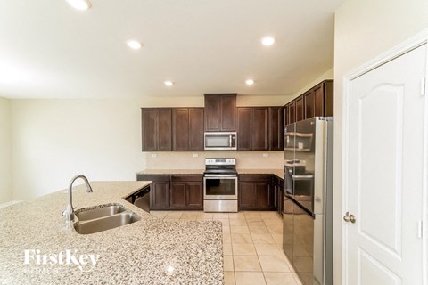 A kitchen with brown cabinets and a sink.