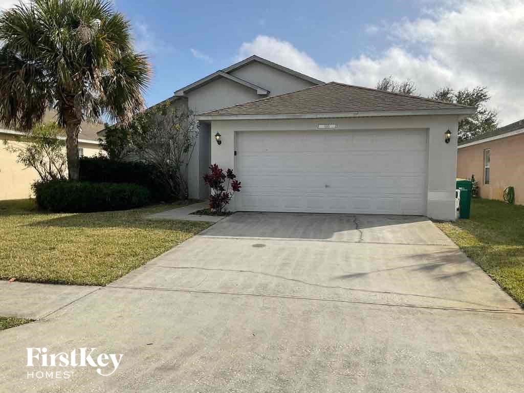 A house with a garage and a driveway in front of it.
