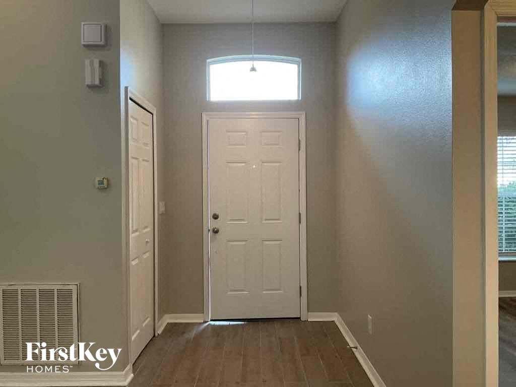 A room with a white door and a window above it.