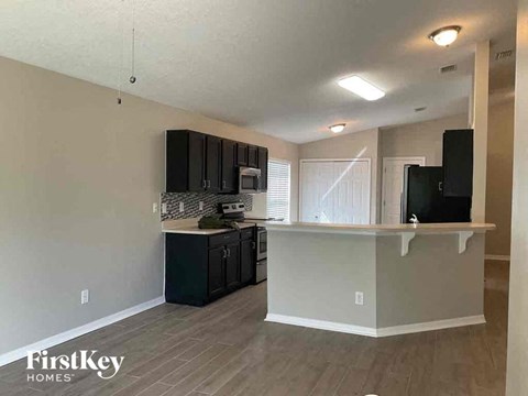 A kitchen with a white countertop and black cabinets.