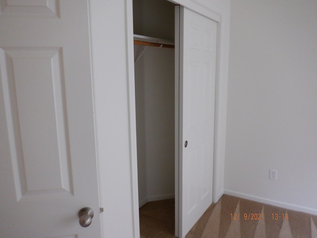 A white door is open to a room with a carpeted floor.