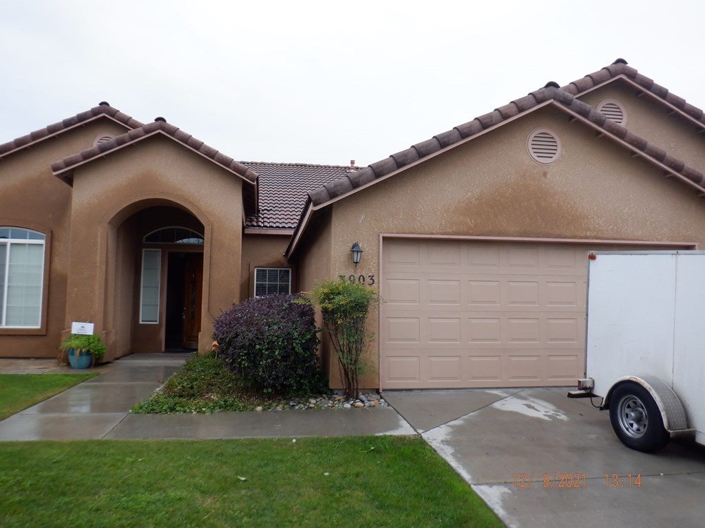 A house with a brown stucco exterior and a white garage door.