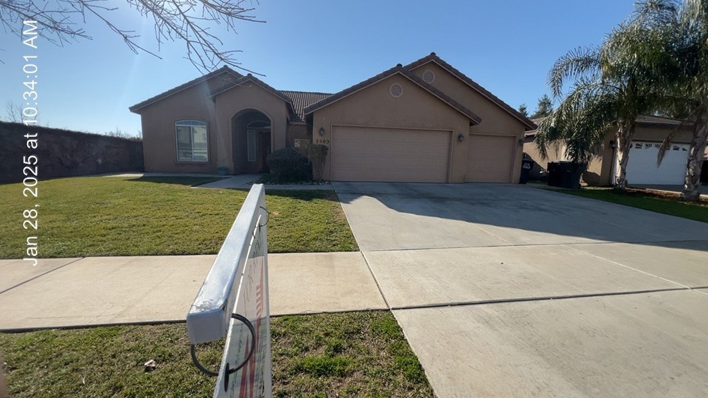 A house with a driveway and a white fence in front.